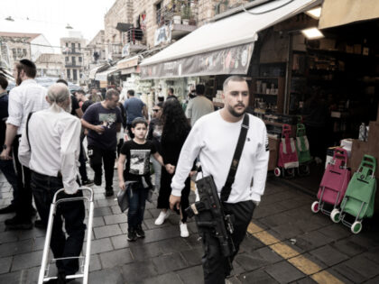 JERUSALEM - NOVEMBER 17: People casually walk the streets with long-barreled weapons after