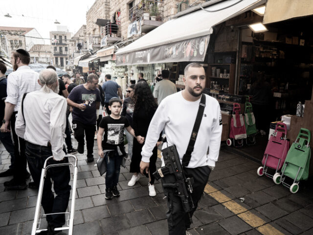 JERUSALEM - NOVEMBER 17: People casually walk the streets with long-barreled weapons after the Israeli government encouraged civilians to arm themselves in West Jerusalem, on November 17, 2023. It has been reported that the number of applications for gun licenses in Israel has exceeded 190,000 since October 7. (Photo by …