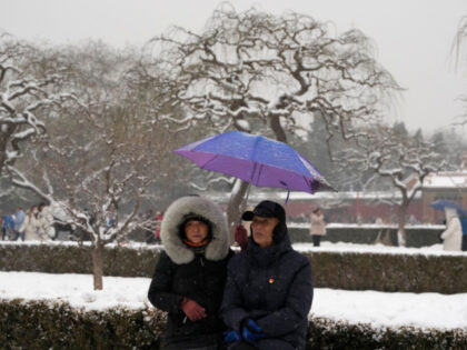 An elderly couple rest in Jingshan Park in Beijing, Wednesday, Dec. 13, 2023. Throngs of p