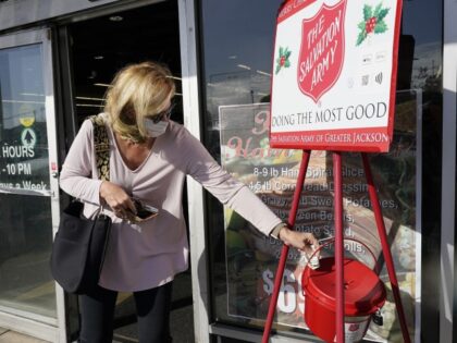 A Corner Market grocery store customer places money in the iconic Salvation Army donations