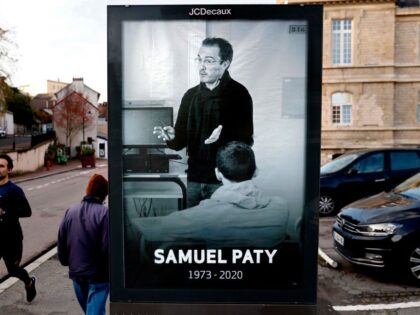 Pedestrians pass by a poster depicting French teacher Samuel Paty placed in the city cente