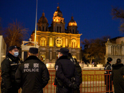 Policemen stand in front of St. Joseph's Church during a mass on Christmas eve in Beijing