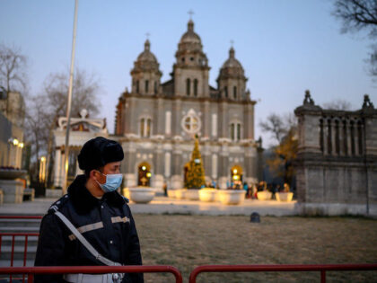 A security guard wearing a face mask stands guard at St. Joseph's Church during a mas