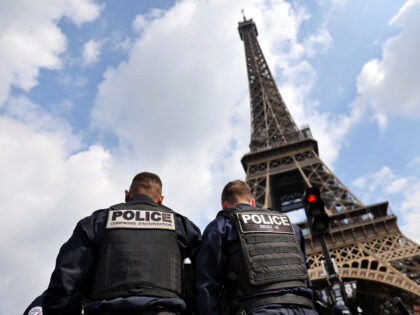 Police officers are seen in front of the Eiffel Tower during a large police operation arou