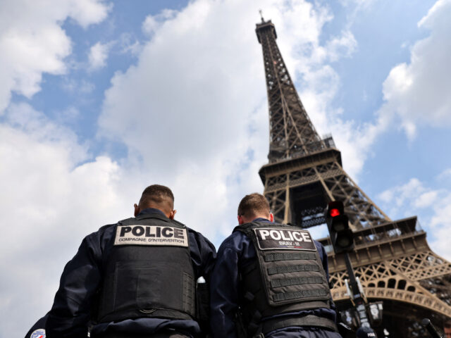 Police officers are seen in front of the Eiffel Tower during a large police operation around the Eiffel Tower area in Paris, on April 26, 2022. Police organized a punch operation against crooks and thieves, tuktuk drivers and illegal street vendors in this high volume touristic area. (Photo by Thomas …