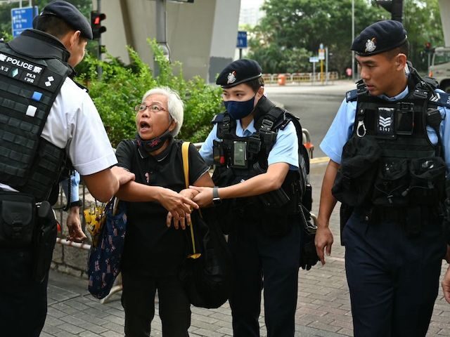 Pro-democracy activist known as Grandma Wong is escorted away by police outside court wher