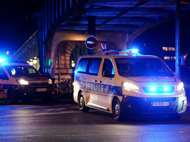 Police vehicles are seen near the scene of a stabbing in Paris on December 2, 2023. An att