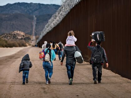 SAN DIEGO, CA - NOVEMBER 30: Asylum seekers walk along the U.S.-Mexico border barrier on t