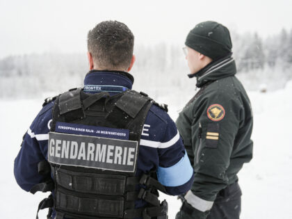 A frontex official and a Finnish border guard stand near the closed Vaalimaa border statio