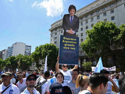 A supporter of Argentina's President-elect Javier Milei holds a banner that reads "Make Ar
