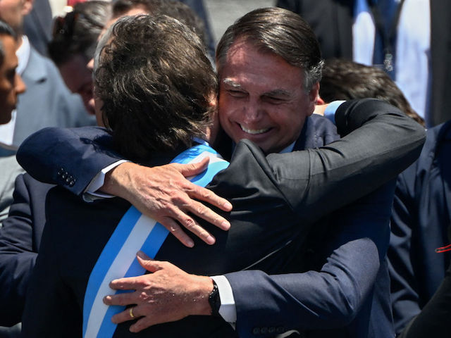 Argentina's new president Javier Milei is embraced by Brazil's ex-president (2019-2022) Jair Bolsonaro after delivering his inaugural speech at the steps of the Congress in Buenos Aires on December 10, 2023. Libertarian economist Javier Milei was sworn in Sunday as Argentina's president, after a resounding election victory fuelled by fury over the country's economic crisis. (Photo by Luis ROBAYO / AFP)