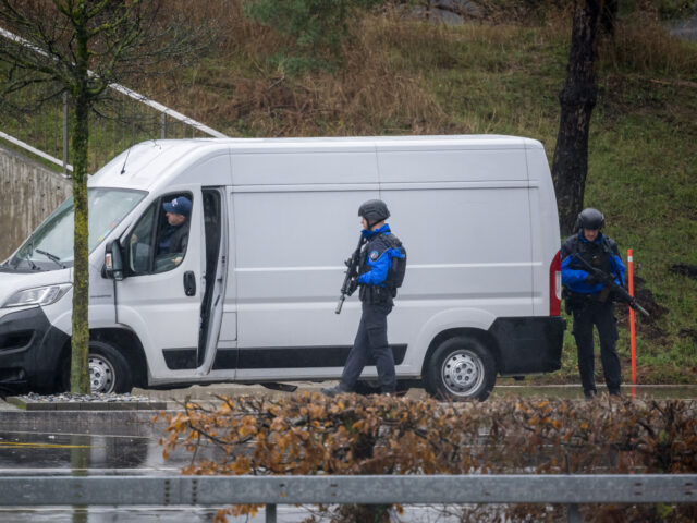 Police officers check a van near Saint Maurice, as they search for a gunman who killed two