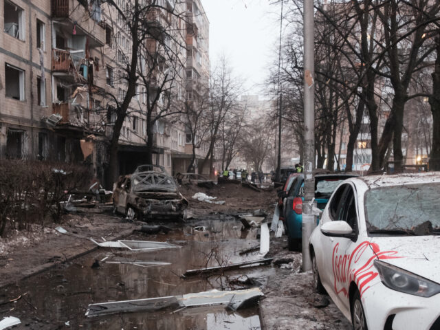 KYIV, UKRAINE - DECEMBER 13: Damaged cars and a residential apartment building are seen af