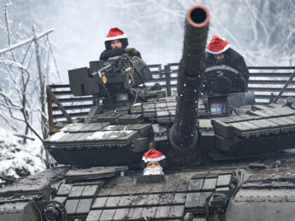 BAKHMUT REGION, UKRAINE - DECEMBER 24: The tank crew in a Christmas outfit goes to perfor