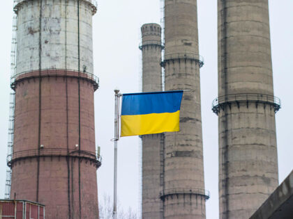 A Ukrainian national flag flies beneath chimneys at the Luhansk thermal power station, ope