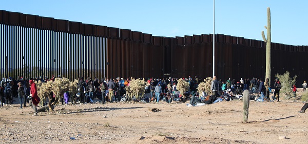 Migrants wait in a makeshift camp at the base of a border wall near Lukeville, Arizona. (Randy Clark/Breitbart Texas)