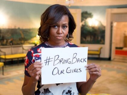 Then-First Lady Michelle Obama holds up a hashtag, "#BringBackOurGirls," to prot