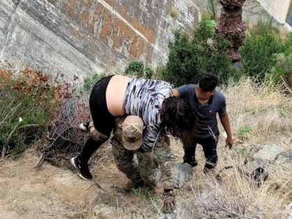 A San Diego Sector BORSTAR agent carries an injured migrant woman up a near-1,000' cliff n
