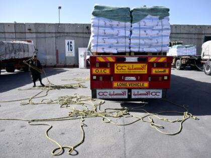 A truck driver re-loads his humanitarian aid cargo after inspection by Israeli security up