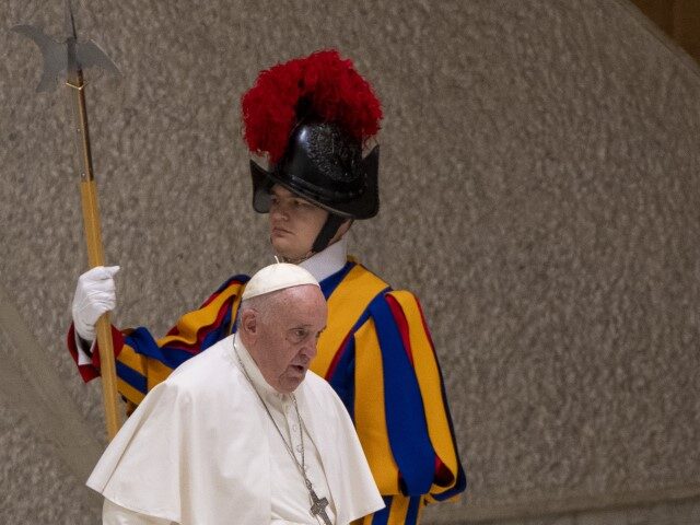 Pope Francis walks by a pontifical Swiss guard as he arrives for an audience with the &#03