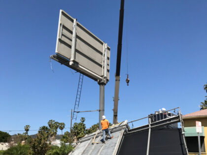 Workers remove a billboard downed by high winds in Los Angeles Friday, March 31, 2017. Gus