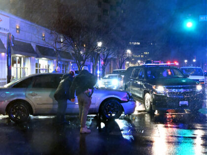 Members of the US Secret Service rush to a car, after it hit a motorcade SUV, as US presid