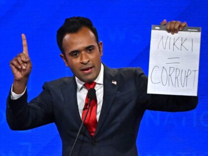 Entrepreneur Vivek Ramaswamy holds up a sign reading "Nikki = corrupt" referring