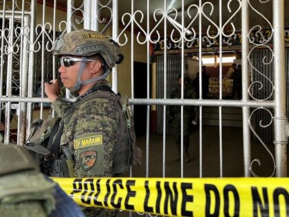 TOPSHOT - Military personnel stand guard at the entrance of a gymnasium while police investigators look for evidence after a bomb attack at Mindanao State University in Marawi, Lanao del sur province on December 3, 2023. At least three people were killed and seven wounded in a bomb attack on …