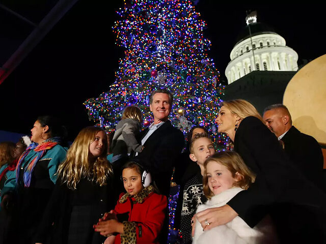 Gov. Gavin Newsom, center, holding his son, Dutch is joined by his wife first partner Jenn