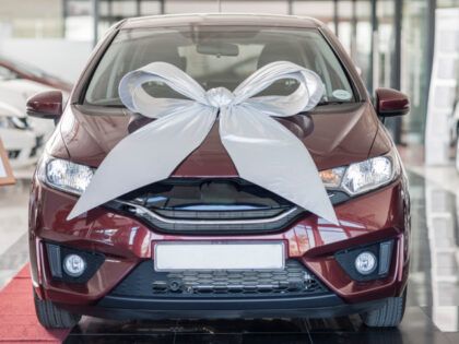 New car with bow in showroom (Stock photo via Getty)