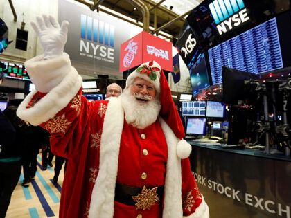 A man in a Santa Claus costume gestures on the floor at the closing bell of the Dow Indust