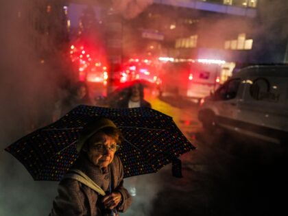 A woman walks under the rain in a street of Manhattan in New York city on December 1, 2023