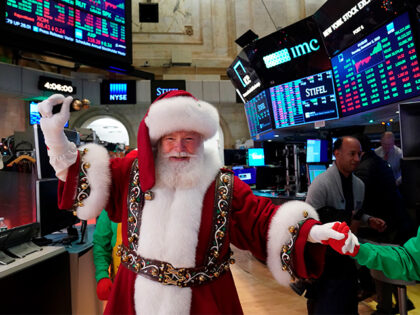 A man in a Santa Claus costume gestures on the floor at the closing bell of the Dow Indust