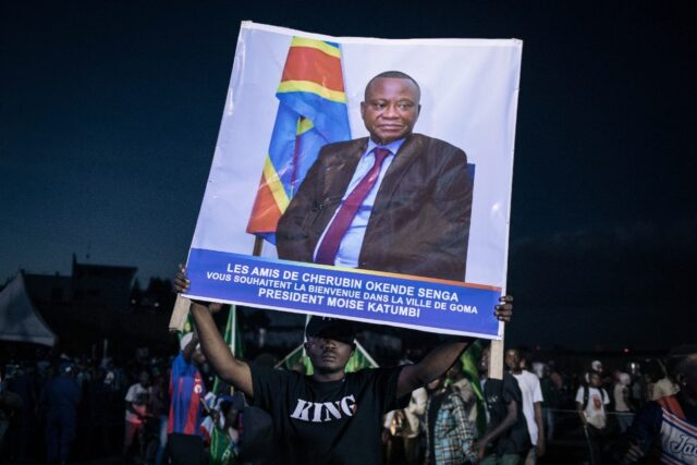 An opposition supporter at a rally in Goma last month with a poster of Cherubin Okende, w