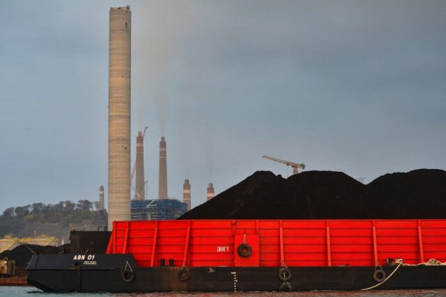 A barge carries coal to the dock next to the Suralaya coal-fired power plant in Cilegon, i