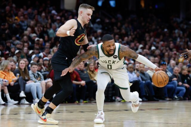 Damian Lillard of the Milwaukee Bucks drives on Sam Merrill of the Cleveland Cavaliers dur