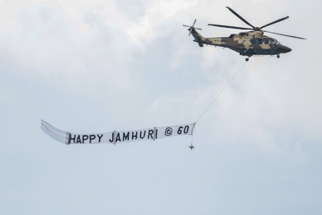 A Kenyan military helicopter carries a banner during the national celebration to mark Keny