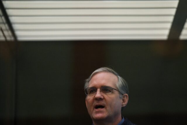 Paul Whelan stands inside a defendants' cage as he waits to hear his verdict in Moscow in