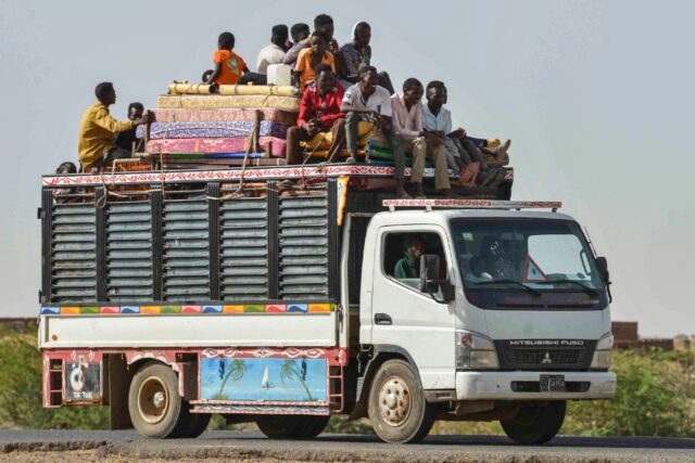 People move on June 22, 2023 along a road from Khartoum to Wad Madani, which became a safe