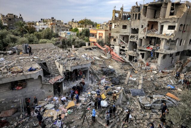 Men recover the body of a victim killed after an Israeli strike at Al-Maghazi refugee camp