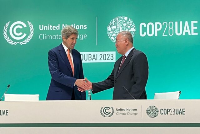 US climate envoy John Kerry (L) and his Chinese counterpart Xie Zhenhua shake hands at a j