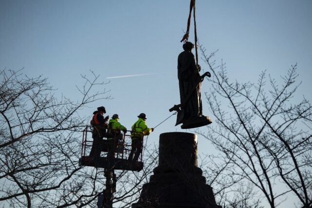 Workers remove a statue from atop the Confederate Memorial at Arlington National Cemetery