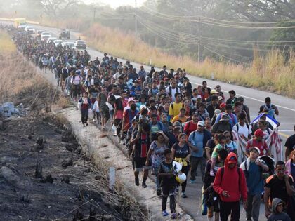 Migrants walk along the highway through Arriaga, Chiapas state in southern Mexico, Monday,