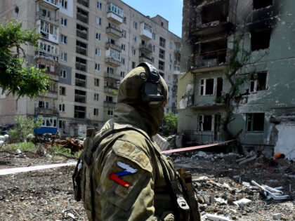 TOPSHOT - A Russian serviceman patrols a destroyed residential area in the city of Severod