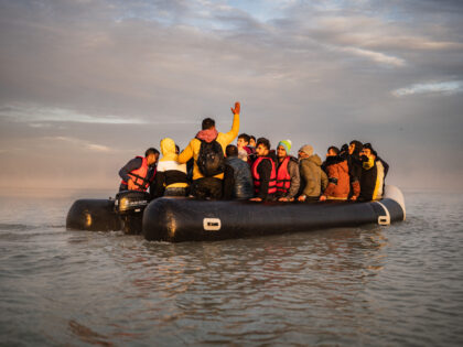 TOPSHOT - Migrants sail after boarding a smuggler's boat on the beach of Gravelines, near