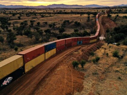 TOPSHOT - An aerial image shows a border wall constructed of shipping containers and toppe