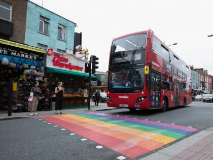 LONDON, ENGLAND - JULY 04: Members of the Public walk over the LGBT road painted sign on C