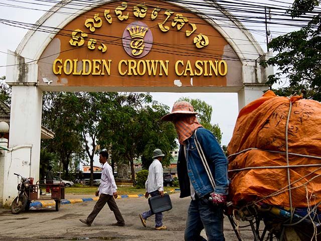 Pedestrians pass by the Golden Crown Casino in the border town of Poi Pet, Cambodia, on Th