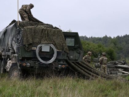 US soldiers of an artillery unit camouflage a vehicle during the NATO exercise 'Saber
