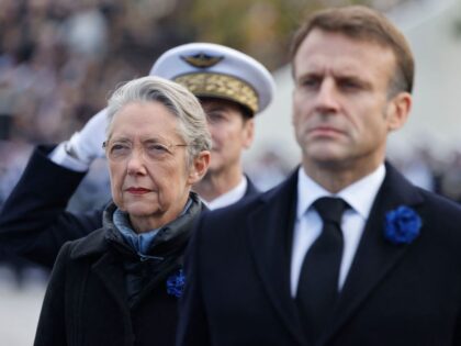 French President Emmanuel Macron, flanked by French Prime Minister Elisabeth Borne, attend
